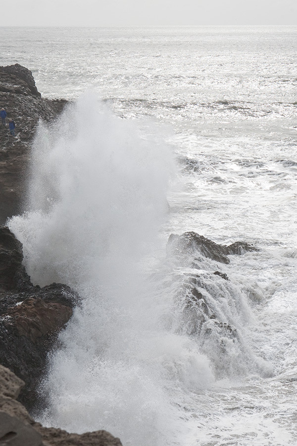 Waves breaking, Dyrholaey peninsula, Iceland. For scale, note the two men in blue jackets at the upper left.